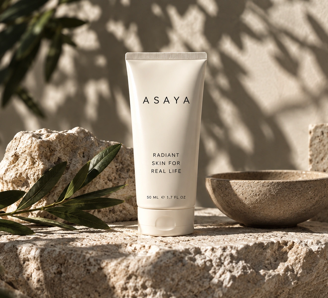 Skincare product photographed among stones and botanical elements